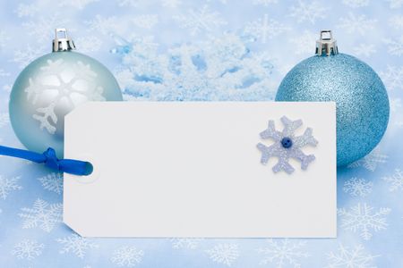 A blank gift tag on a blue snowflake backgroundの写真素材