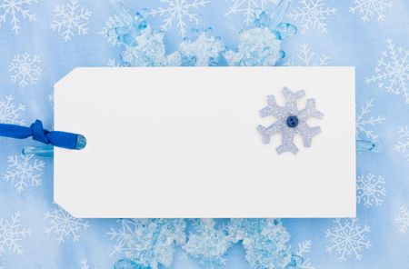 A blank gift tag on a blue snowflake backgroundの写真素材