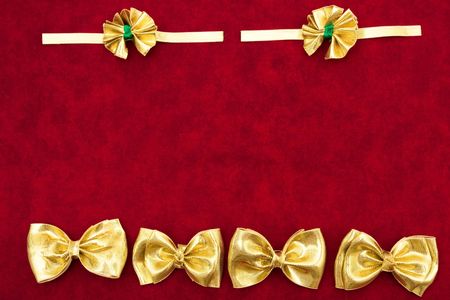 A gold ribbon bows sitting on a red backgroundの写真素材