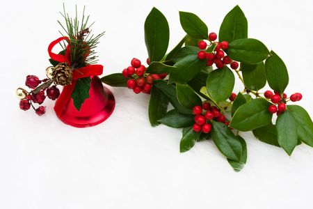 A red bell with holly berry on a white backgroundの写真素材