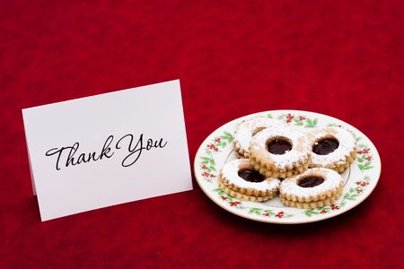 A plate of sugar cookies and a blank card on a red backgroundの写真素材
