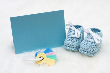Baby booties with a blank card sitting on a white backgroundの写真素材