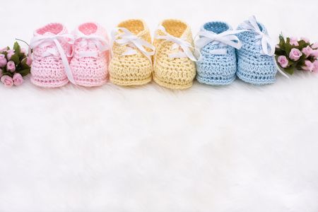 Three pairs of baby booties on a white backgroundの写真素材