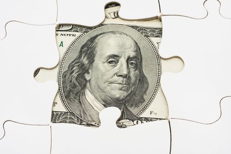 White puzzle on one hundred dollar bill, solving money problemsの写真素材