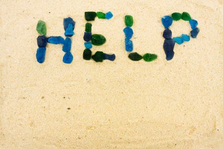 Beach glass spelling help in the sand, helpの写真素材