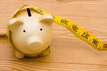 A piggy bank with a measuring tape, Measuring your successの写真素材