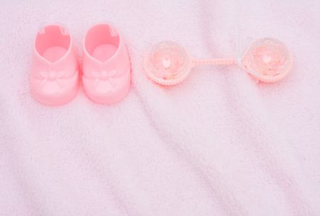 Pink baby booties on a pink textured background, baby bootiesの写真素材