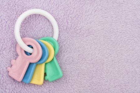 A key shaped baby rattle on a lavender textured background, Baby Rattle with copy spaceの写真素材
