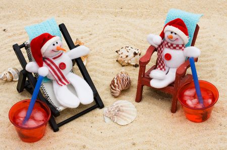 A lounge chair with snowmen on a sand background, Relaxing on your winter vacation の写真素材