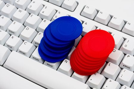 Poker chips sitting on a computer keyboard, online pokerの写真素材
