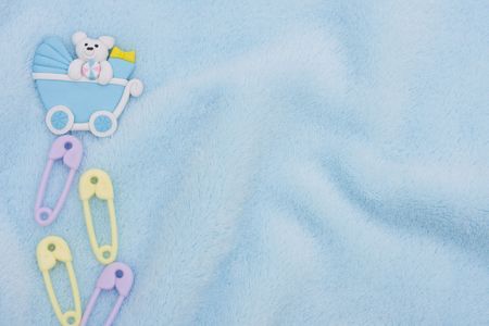 Diaper pins and a baby carriage on a blue textured background, baby borderの写真素材