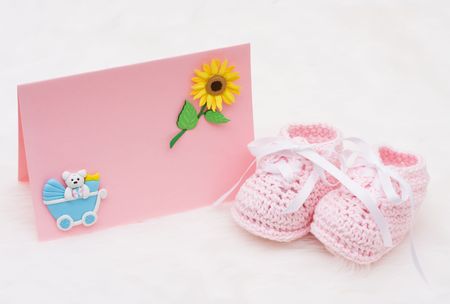 A pair of baby booties with a blank card on a white background, Baby Announcementの写真素材