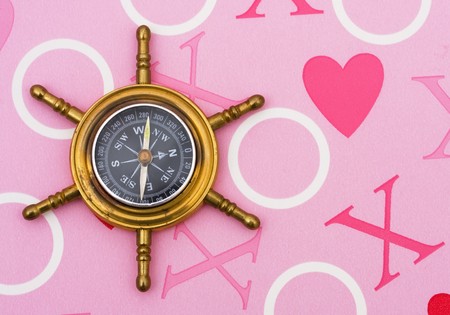 A compass on a heart background, finding loveの写真素材