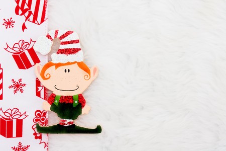 An Elf  with a red ribbon on a white fur backgroundの写真素材