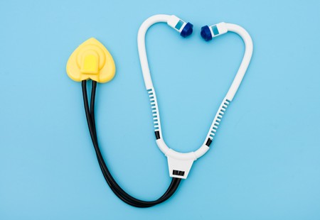 A toy stethoscope on a blue background, healthcareの写真素材