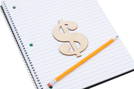 A pencil on a workbook with a dollar sign isolated on a white background, Costs of an educationの写真素材