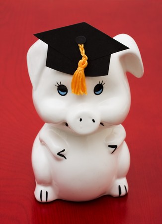 Piggy bank with graduation cap on a wood background, education savingsの写真素材