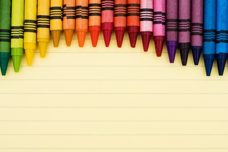 Colorful crayons on a sheet of lined paper, Educational backgroundの写真素材