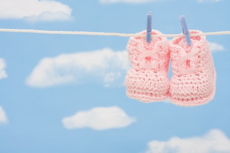 Retro hand made baby booties hanging on a clotheslineの写真素材
