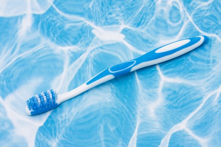 A blue toothbrush on a white and blue background, good hygieneの写真素材