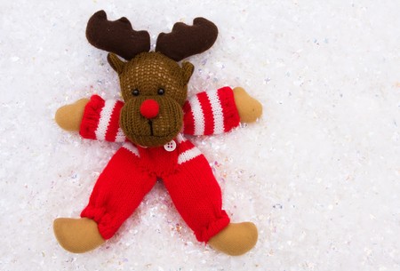 A reindeer playing on a snowflake background, making a snow angel の写真素材