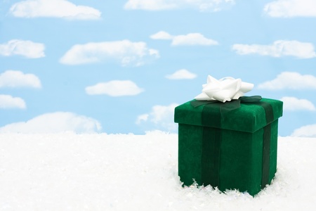 A green christmas present with a bow on a sky background, christmas presentの写真素材