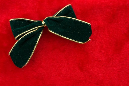 A green velvet bow on a red background, Christmas Timeの写真素材