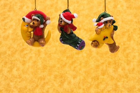 Three teddy bear Christmas tree ornaments on a yellow background, Chritmas Timeの写真素材