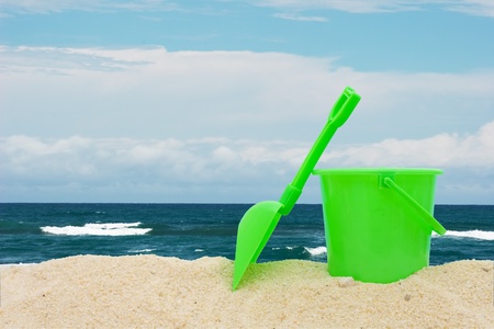 Green bucket and shovel in the sand at the beach, Day at the beachの写真素材