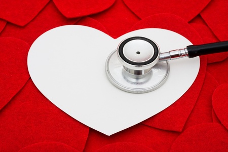 Black and silver stethoscope with a red heart backgroundの写真素材