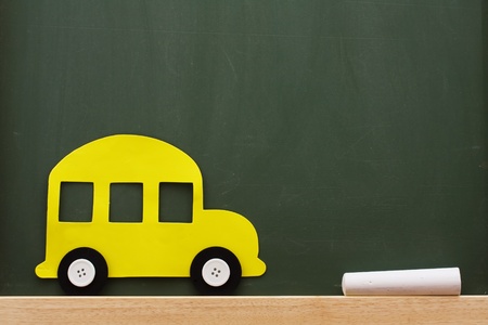 A school bus and chalk on a chalkboard with lots of copy space, School Daysの写真素材