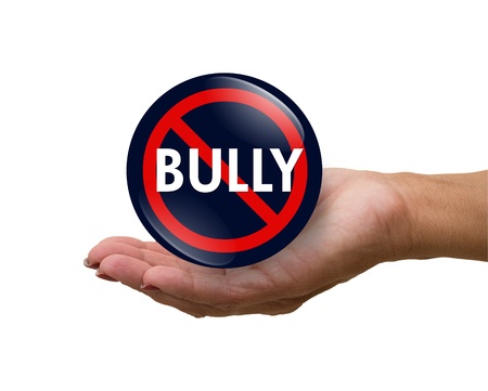 A blue, white and red  button with word Bully isolated on a white background in a hand, No Bully buttonの写真素材