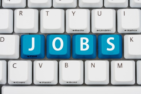 A computer keyboard with blue keys spelling jobs, Applying for jobs on the internetの写真素材