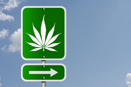 An American road sign with a sky background and marijuana leaf and arrow, Marijuana this wayの写真素材