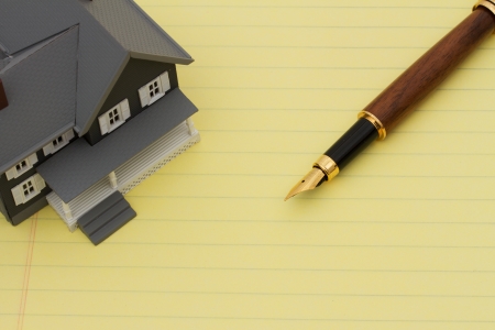 Yellow Lined Paper with model house and pen with copyspace, Signing for your mortgageの写真素材