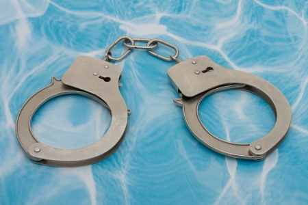 Handcuffs that are closed on a blue background