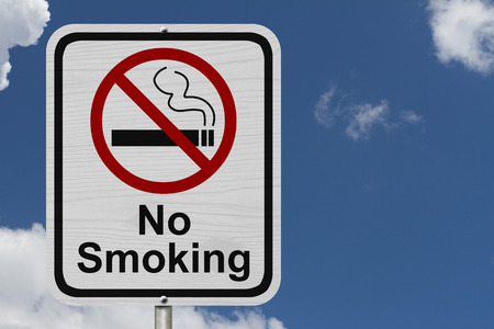 No Smoking Sign, Red and White sign with words No Smoking and cigarette symbol with blue sky backgroundの写真素材