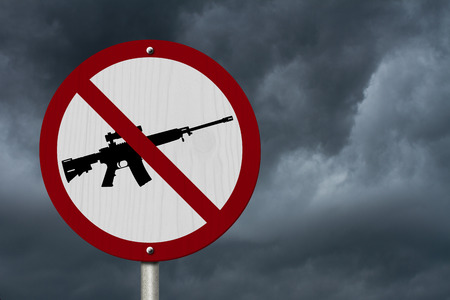No Firearms Allowed Sign, An red road sign with handgun icon and not symbol with stormy sky backgroundの写真素材