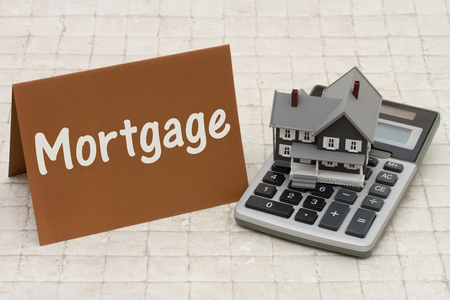 Home Mortgage, A gray house, brown card and calculator on stone background with text Mortgageの写真素材