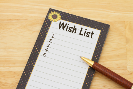 Blank wish list of notepad and paper, A notepad and pen on a desk with text Wish List and copy-spaceの写真素材
