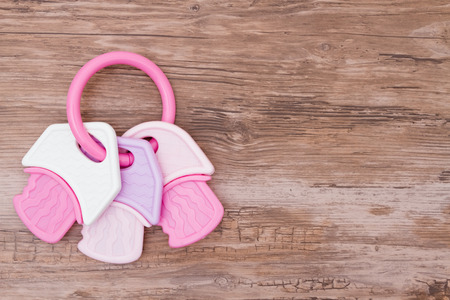 Baby Girl Background, A pink and white teething ring on weathered wood with copy space for your messageの写真素材