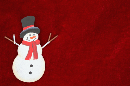 Red plush fabric with a snowman background with copy-space for messageの写真素材