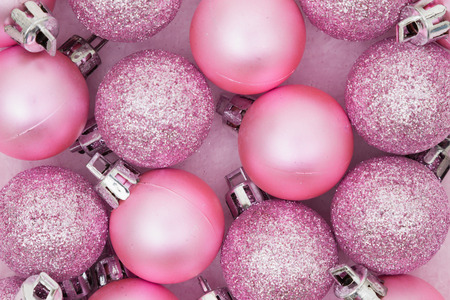 Some pale pink sparkle and matte Christmas ball ornaments backgroundの写真素材