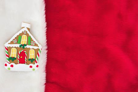Red and White Plush Fabric with a Gingerbread House Background with copy-space for message