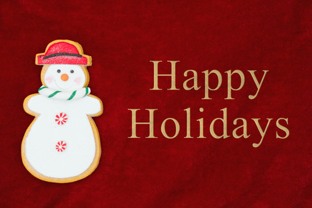 Red plush fabric with a snowman background with text Happy Holidaysの写真素材