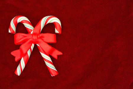 Red plush fabric with candy canes background with copy-space for messageの写真素材