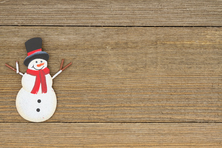 A retro snowman on weathered wood background with copy space for your messageの写真素材