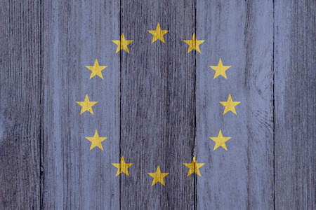 A rustic old EU flag on weathered wood for a backgroundの写真素材