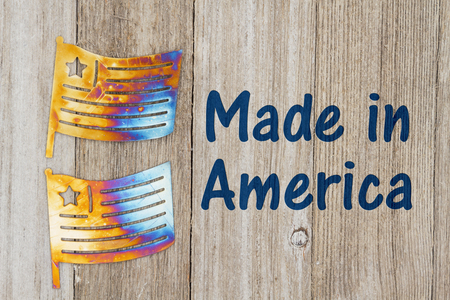 Made in America text with USA patriotic old metal flags on a weathered woodの写真素材