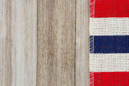 Red, white and blue pip burlap ribbon on weathered wood background with copy space for your messageの写真素材